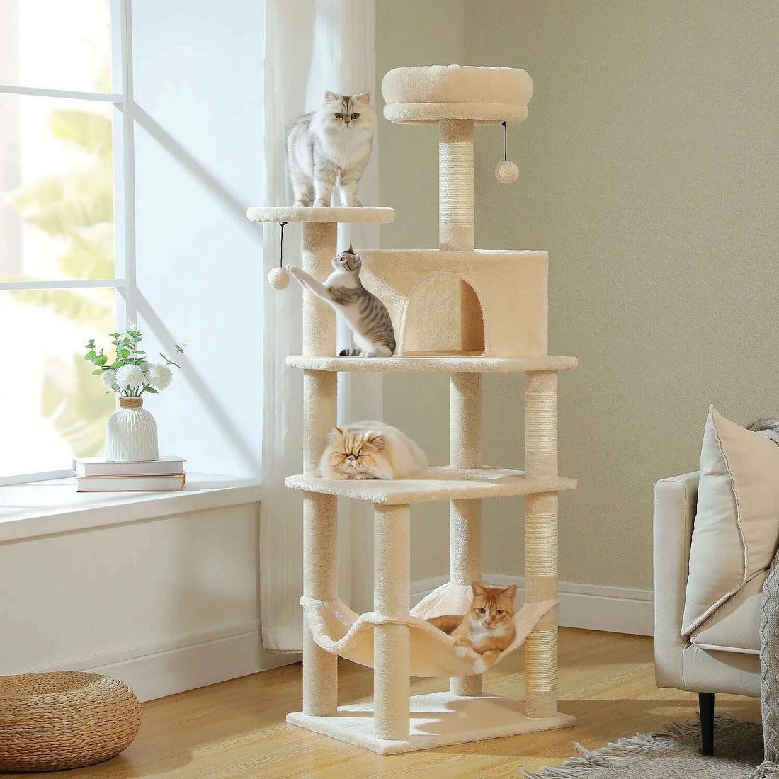 Quatre chats occupent chaque plateforme du modèle beige dans un salon naturel
